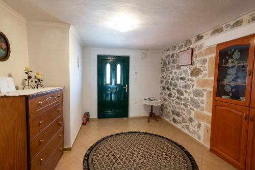 a hallway with a green door and a stone wall at Kamara House in Tyros