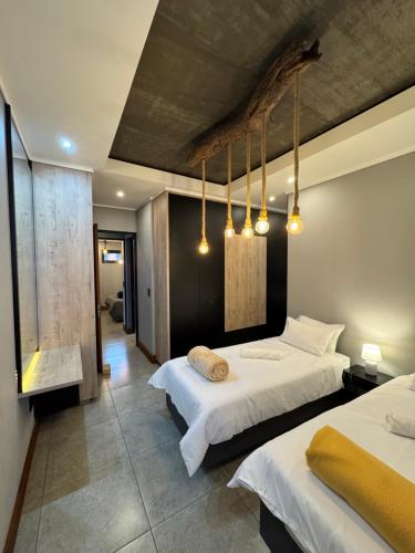a hotel room with two beds and two lights at The Concrete Edit in Benoni
