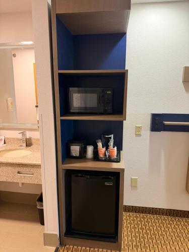 a kitchen with a microwave on a shelf next to a bathroom at Comfort Suites Wisconsin Dells Area in Portage