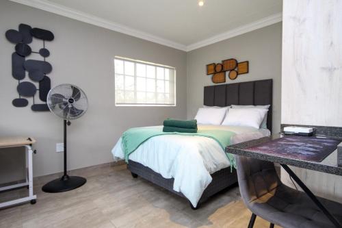 a bedroom with a bed and a fan at Scheunberg 4 Modern 1 Bedroom Flat in Centurion