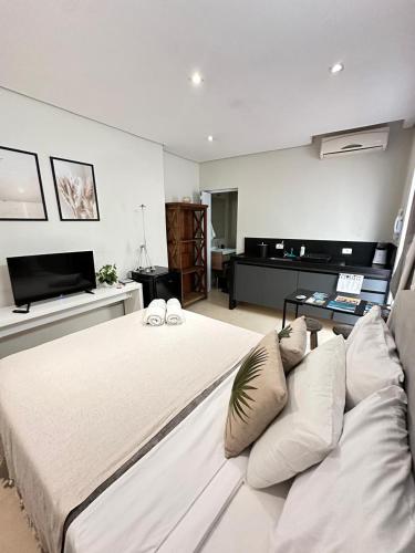 a bedroom with a large white bed with pillows at Studio Matriz 1 e 2 in São Sebastião