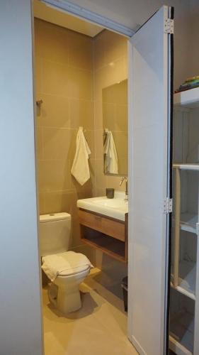 a bathroom with a toilet and a sink and a mirror at Studio Matriz 1 e 2 in São Sebastião