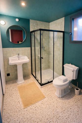 a bathroom with a shower and a toilet and a sink at Tiny Chalet in Paluel