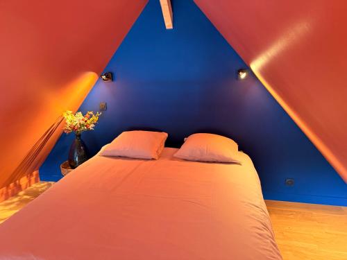 a bed in a room with blue and red walls at Tiny Chalet in Paluel