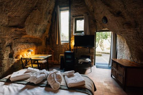 a bedroom with a bed with towels and a table at La Voûte Etoilée in Doué-la-Fontaine