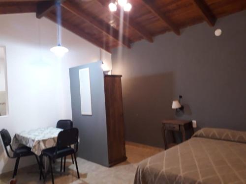 a bedroom with a bed and a table and chairs at Departamentos Algarrobo in Arroyo de Los Patos