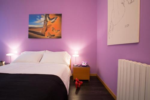 a bedroom with purple walls and a bed with two lamps at Albergo Giardino in Cernobbio