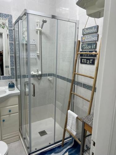 a shower with a glass door in a bathroom at Camurichico in Figueira da Foz