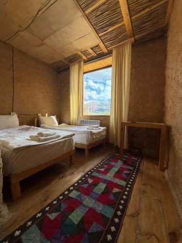 a large room with two beds and a window at KyzArt Hotel & Horse Tours in Bagysh