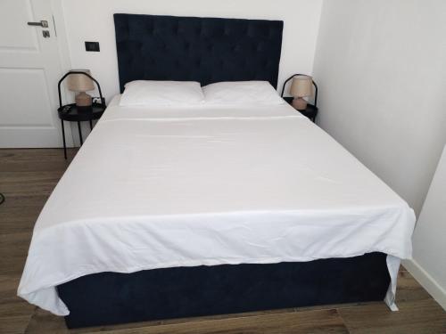 a large bed with a black headboard and white sheets at Premium Lakeside Apartament Building Stefan in Mamaia