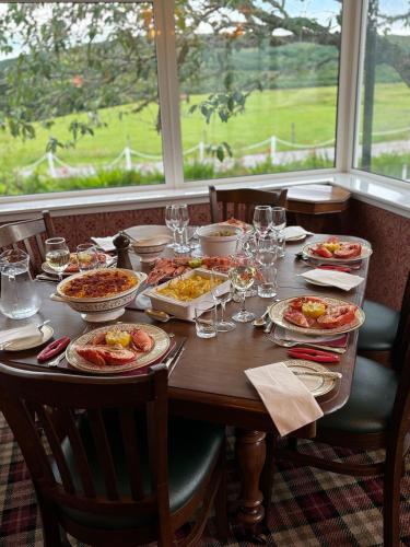 a table with plates of food and wine glasses at Achness Hotel in Lairg