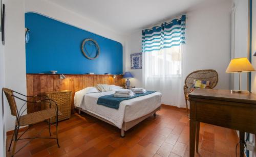 a bedroom with a bed with a blue wall at B65 - Casa Le Ferreira in Praia da Luz in Luz