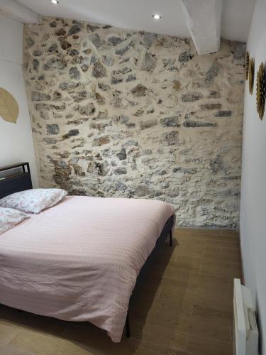 a bedroom with a stone wall and a bed at Appartement T2 - Sète centre ville - A deux pas des Halles in Sète