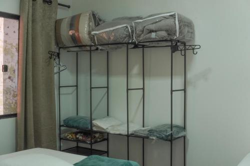 a room with a bed and a shelf with towels at Kitnet confortável in Foz do Iguaçu