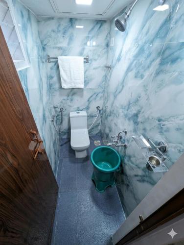 a blue marble bathroom with a toilet and a sink at Belandoor Nature Nest in Sringeri