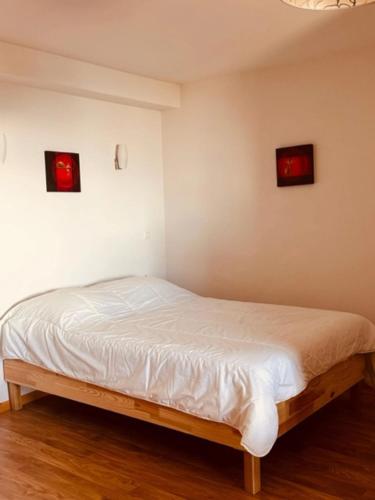 a bed in a room with three pictures on the wall at studio Nivéole 303 in Chamrousse