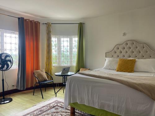 a bedroom with a bed and a table with a laptop at Bright Bay Garden Suite in Montego Bay