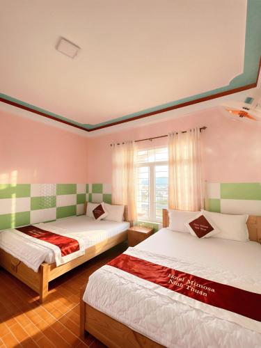 a bedroom with two beds and a window at Mimosa 5 Hotel - Phan Rang in Bắc Sớn