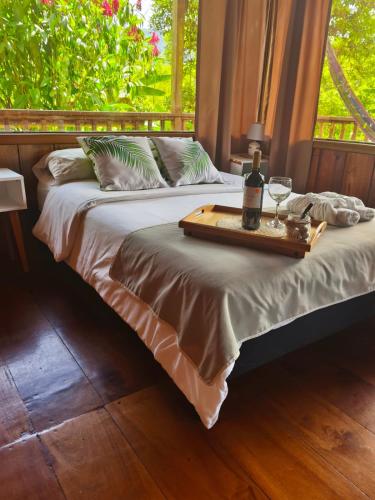 a bed with a tray with a bottle of wine on it at The Temple I, Mindo in Mindo