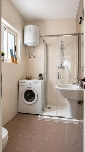 a bathroom with a washing machine and a sink at Calypso 3 Large Stylish Apartment in Paceville with Mercury Tower View Ideal for Groups in St. Julianʼs