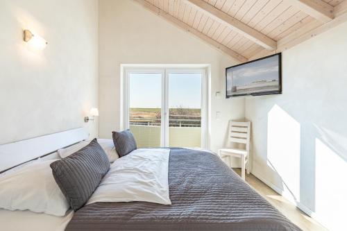 a bedroom with a bed and a tv on the wall at Ferienhaus Basstölpel in Dagebüll