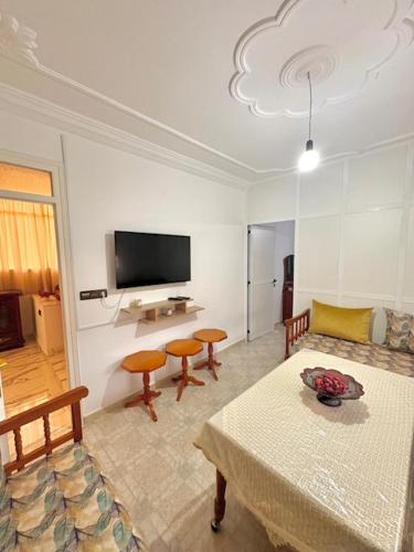 a living room with a table and a tv at Appartement Ajdir in Al Hoceïma