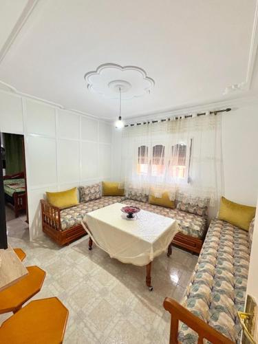 a living room with couches and a table and a couch at Appartement Ajdir in Al Hoceïma