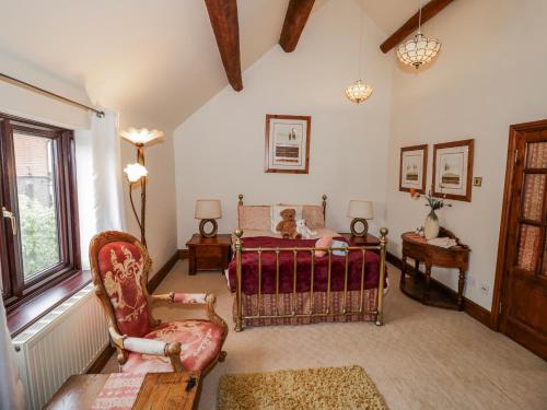 a bedroom with a bed and a chair at The Haybarn in Lichfield
