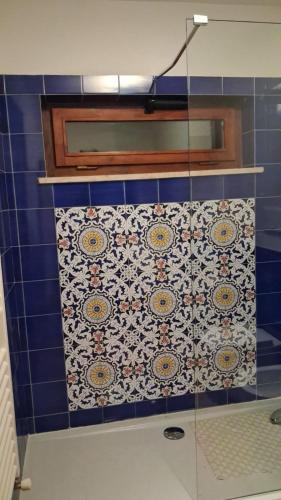 a bathroom with a blue tiled wall with a window at Casa Daniela in Velletri