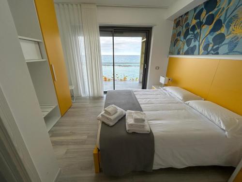 a bedroom with a large bed with a view of the ocean at Yellow Dream B&B in Torre Melissa