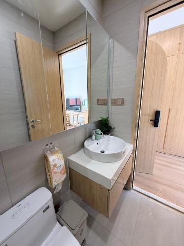 a bathroom with a sink and a toilet and a mirror at Victoria home in Vĩnh Thái
