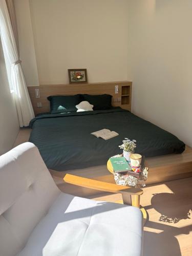 a bedroom with a bed with a table next to it at Victoria home in Vĩnh Thái