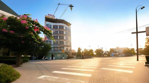a city street with a tall building with a crane at Mimosa 7 Hotel - Phan Rang in Phan Rang–Tháp Chàm
