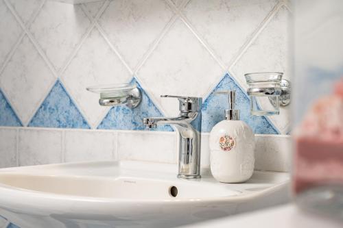a bathroom sink with a soap dispenser on it at Thalia's Cottage - Cozy, Romantic Retreat with Sea & Mountain views in Kámpos