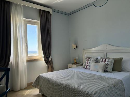 a bedroom with a white bed and a window at Relais Antiche Saline in Torre Nubia