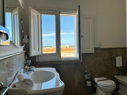 a bathroom with a tub and a sink and a toilet at Relais Antiche Saline in Torre Nubia