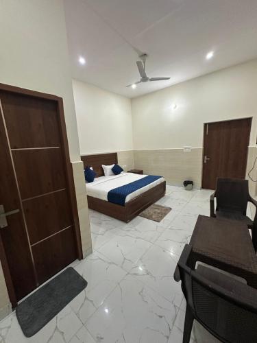 a bedroom with a bed and a chair and a table at Hotel Gold in Faridabad