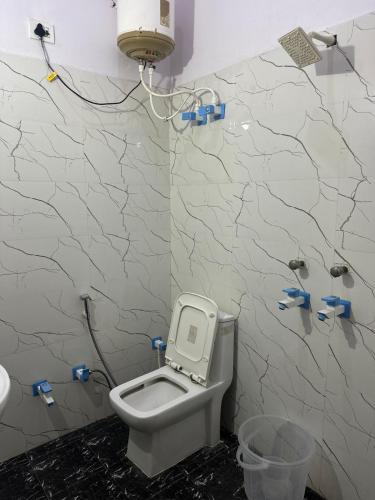 a bathroom with a white toilet in a room at Hotel Gold in Faridabad