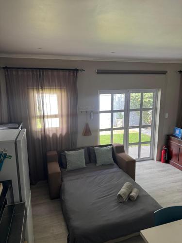 a living room with a couch and a large window at Lavender Grove in George