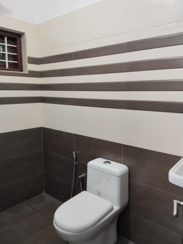 a bathroom with a toilet and a sink at Aditi Residency in Cochin