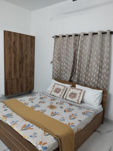 a bed with a headboard and three pillows on it at Aditi Residency in Cochin