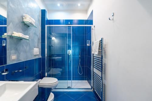 a blue bathroom with a shower and a toilet at My Suite Sorrento in Sorrento