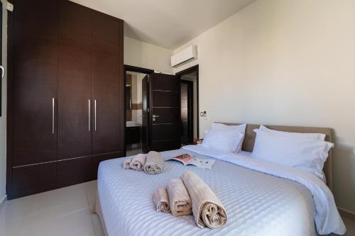 a bedroom with a bed with towels on it at Ixia Pool Villa with sea view roof top in Ixia