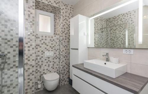 a bathroom with a sink and a toilet and a mirror at Kuća za odmor Katini dvori in Novalja