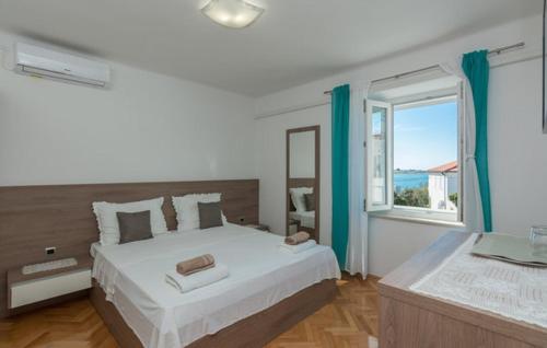 a bedroom with a large bed and a window at Kuća za odmor Katini dvori in Novalja
