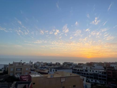 a view of a city with the sunset in the background at Mavi Surf Stay Tamraght in Tamraght Ouzdar