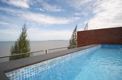a swimming pool with a view of the water at Hommie Home Pattaya in Ban Krathing Lai