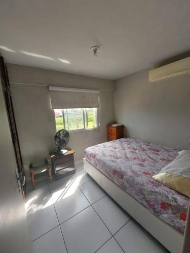 a bedroom with a bed and a window at Apartamento 2 quartos Centro de Araranguá in Araranguá