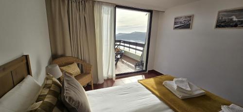 a bedroom with a bed and a large window at Apartment with a stunning view over Sesimbra in Sesimbra