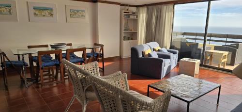 a living room with a table and chairs at Apartment with a stunning view over Sesimbra in Sesimbra